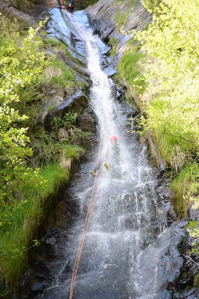 A person rappeling a waterfull in the Estarón canyon in the Pyrenees