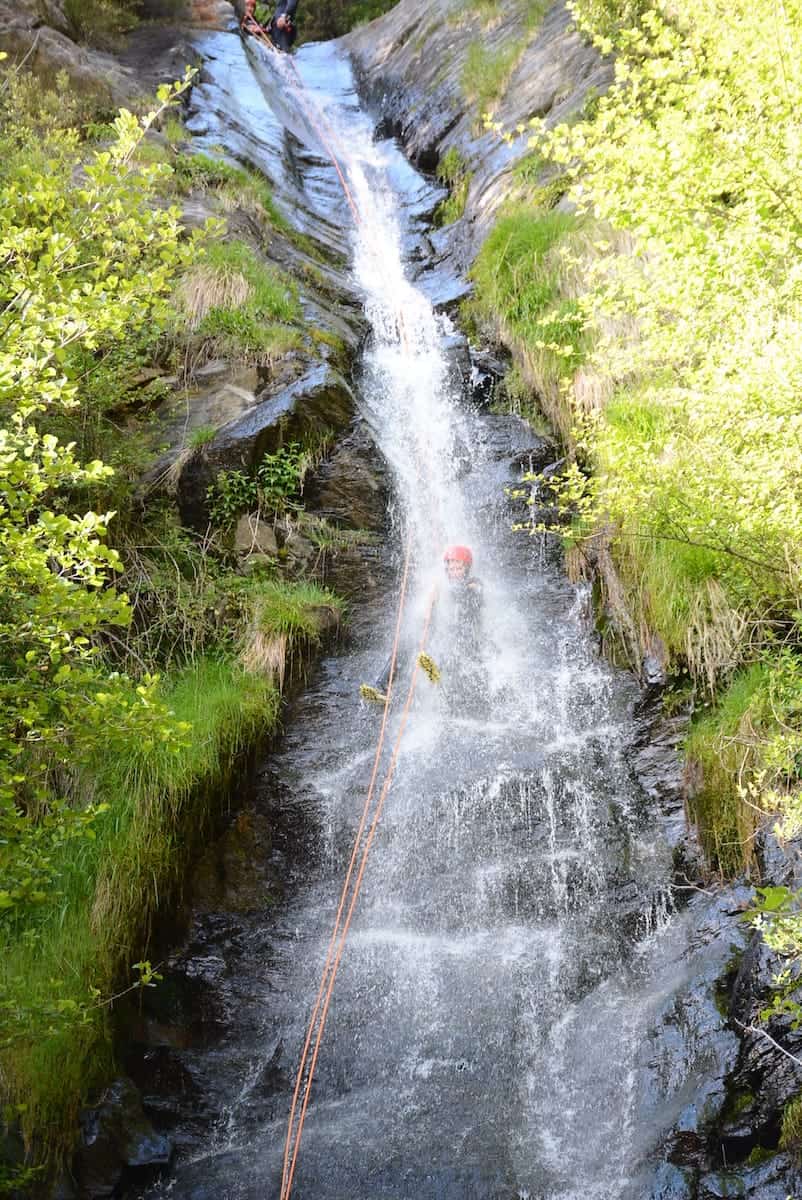 A person rappeling a waterfall in the Estarón Canyon in the Pyrenees