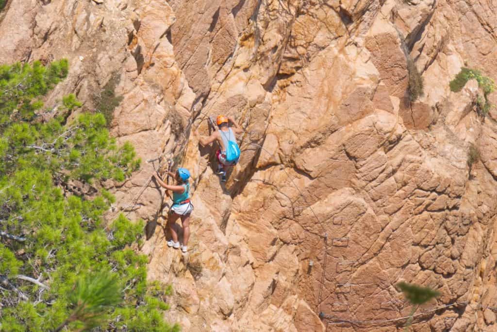 Two people climbing the via ferrata Cala del Molí