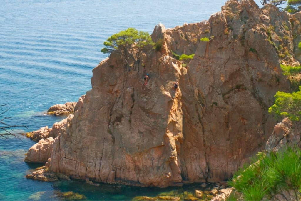A woman climbing overlooking the Mediterranean Sea