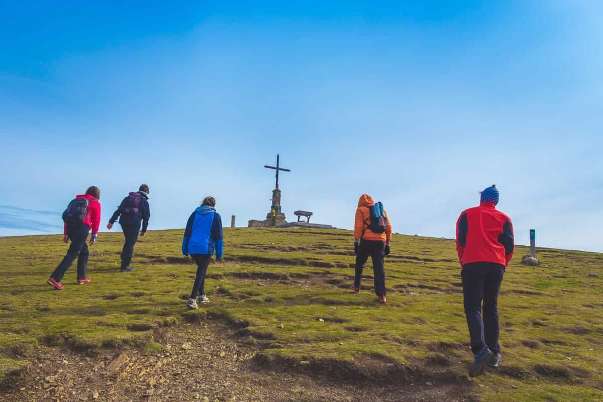 People hiking towards the cross on top of Matagalls mountain