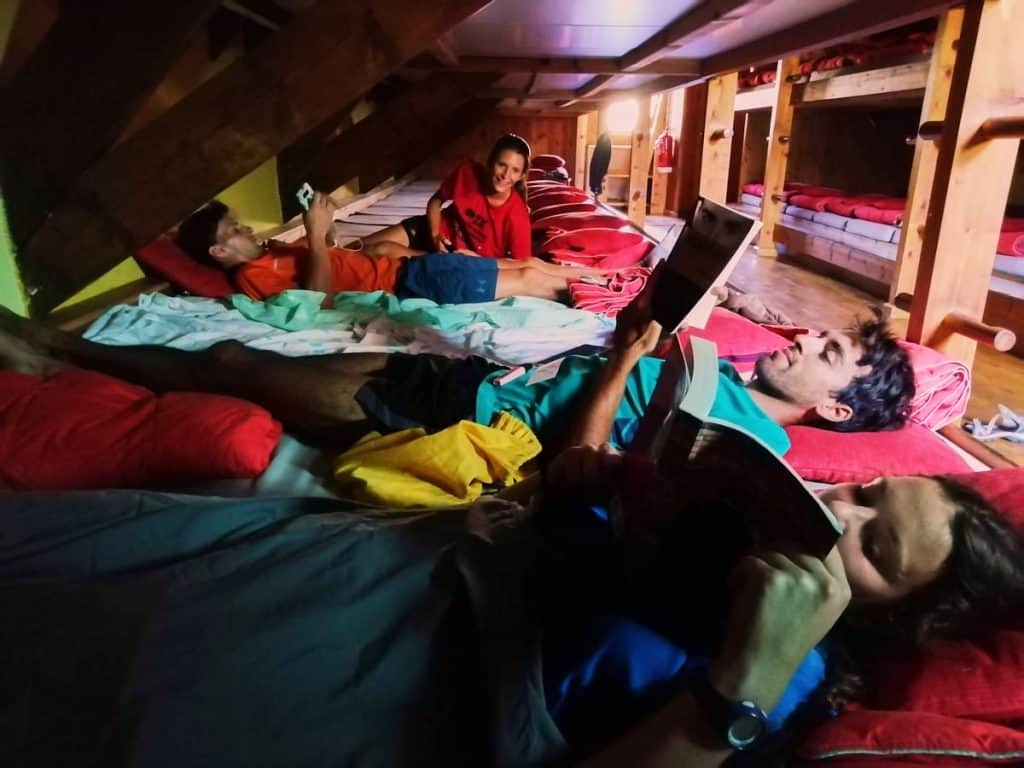 People chilling and resting in a room in one of the mountain huts of Carros de Foc