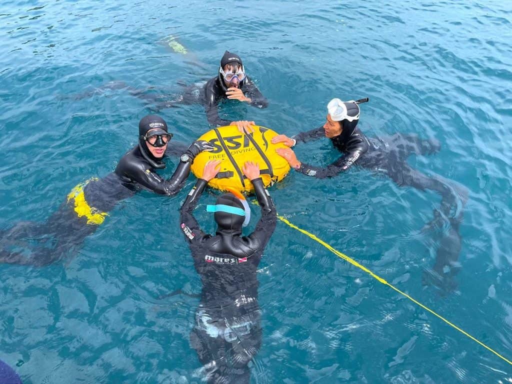 People doing breathing exercises before freediving