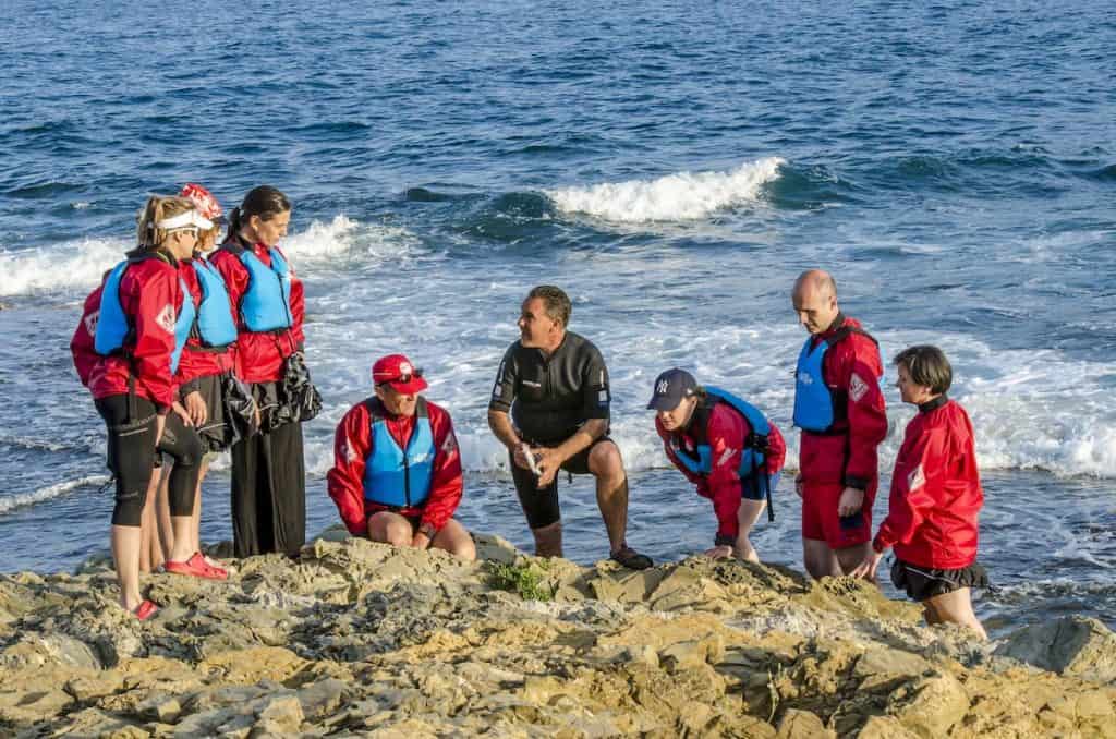 A group of people listening to the explanations of a botanist during a foraging experience in the Costa Brava