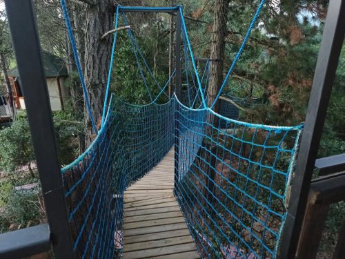 The suspension bridge to enter the treehouse Cabana Nuvol