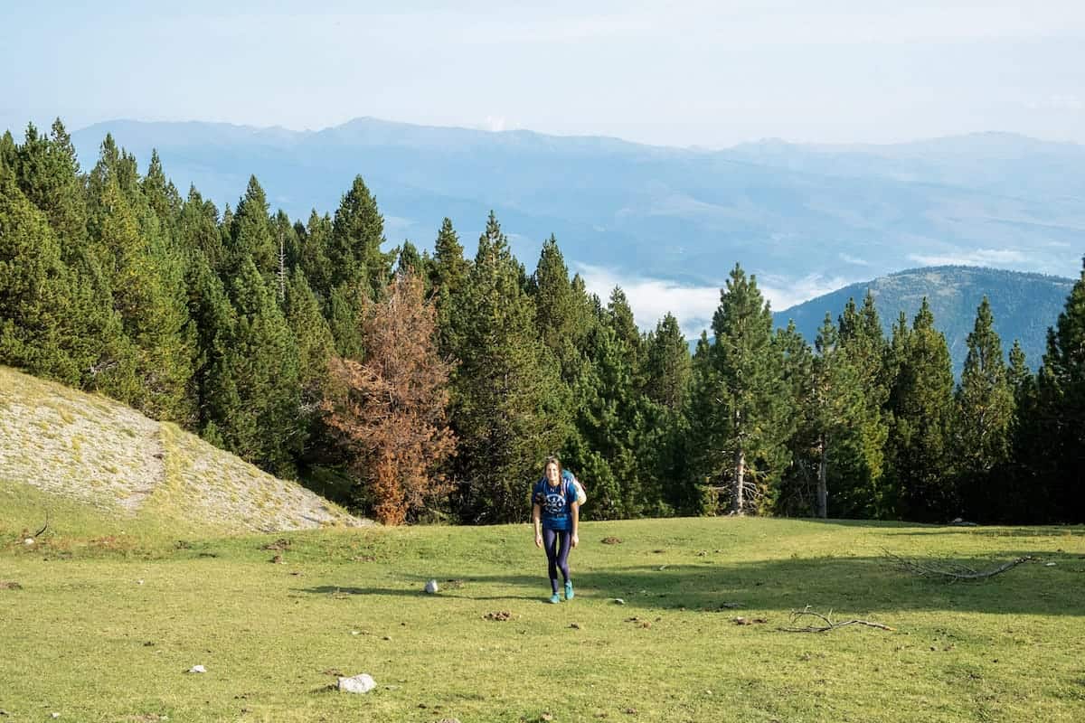 A person hiking in a meadow in the Cavalls del Vent route
