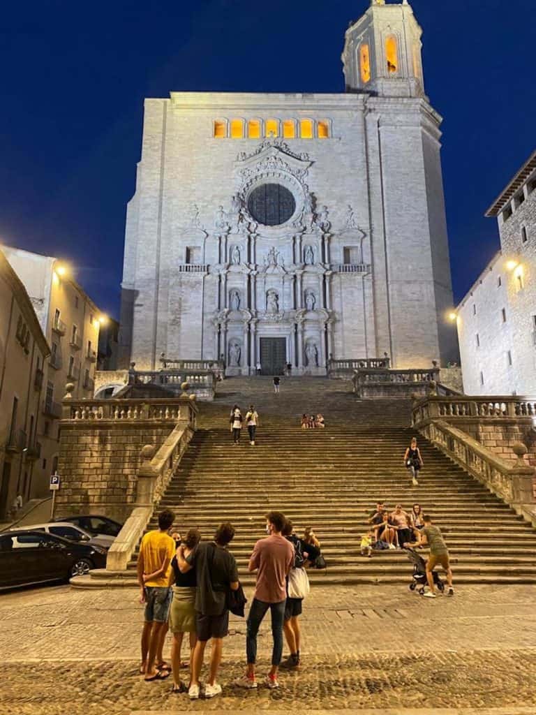 People standing in front of the Girona cathedral at night