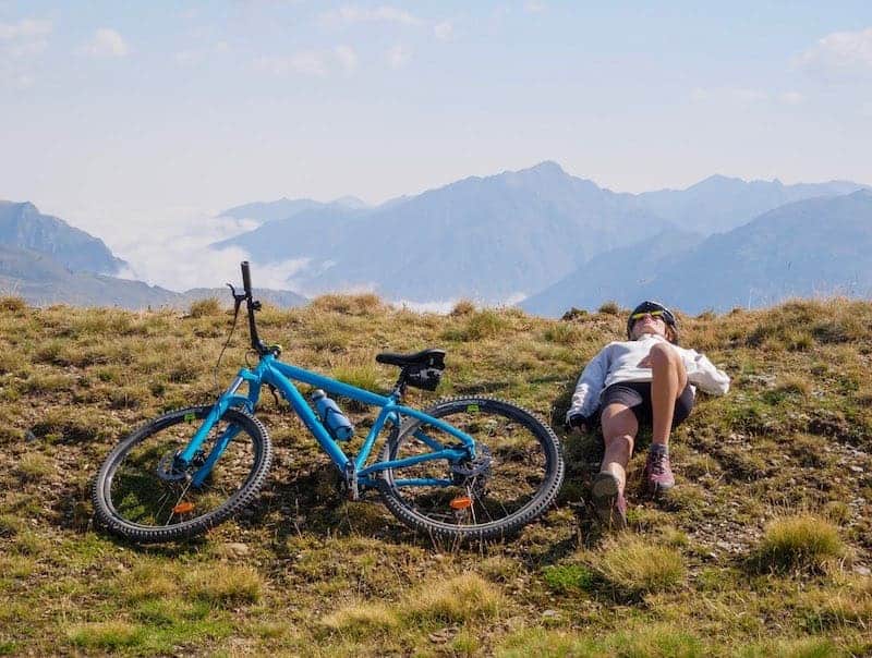 A person chilling in the mountains after a bike ride