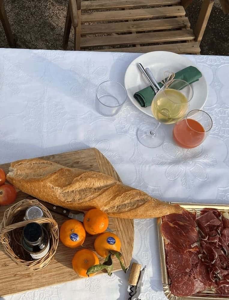 Picnic with bread, fruit, wine and cured meats at Bouquet d'Alella