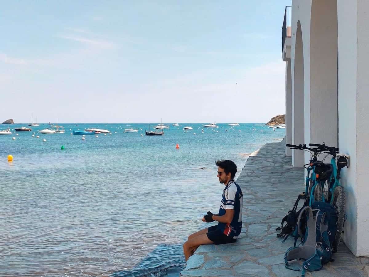 A person sitting in front of the sea in May in Cadaqués (Catalonia)
