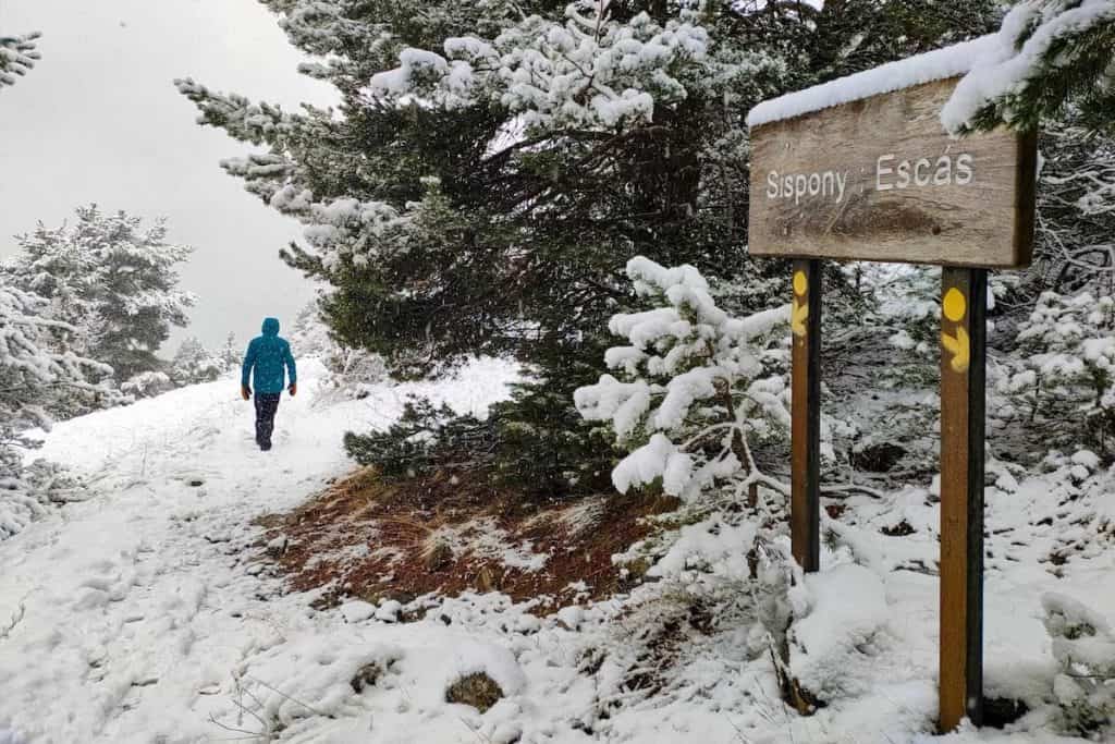 A person passing by a sign indicating the hike to Sispony