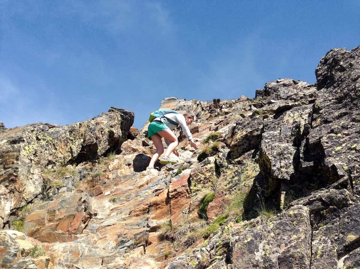 A hiker scrambling to reach the summit