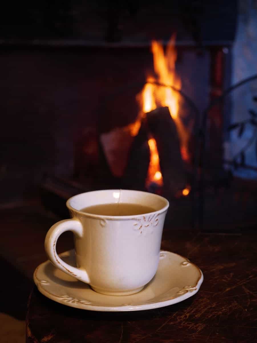 A cup of tea next to the fireplace