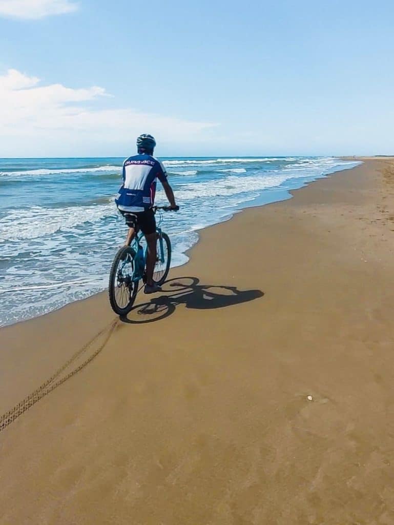 A man cycling on the beach at the Delta de l'Ebre