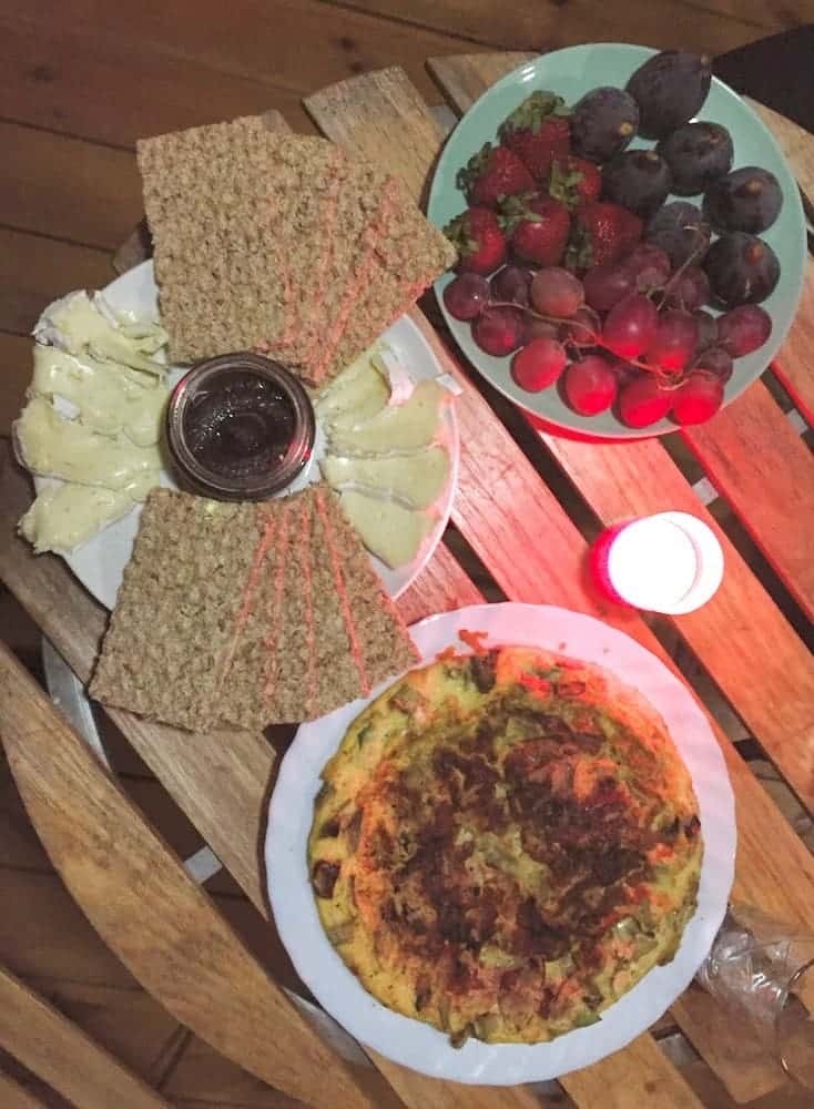 Picnic dinner with cheese, crackers, fruit, and Spanish omelette