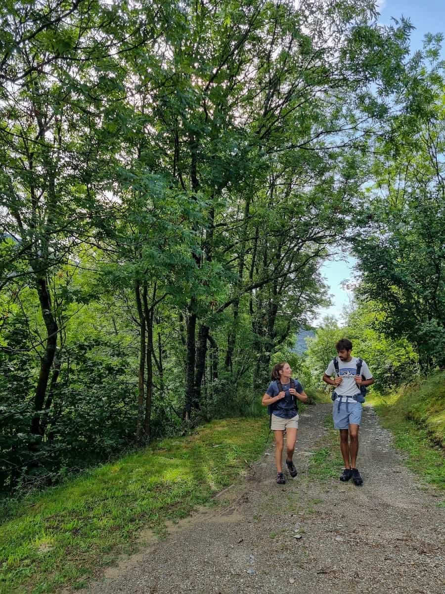 Two hikers walking through the forest on the Estanys Amagats hiking route