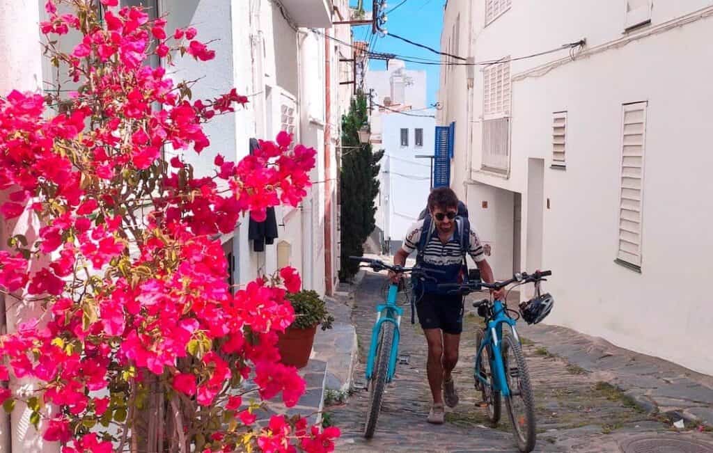 A person carrying two bikes in Cadaqués