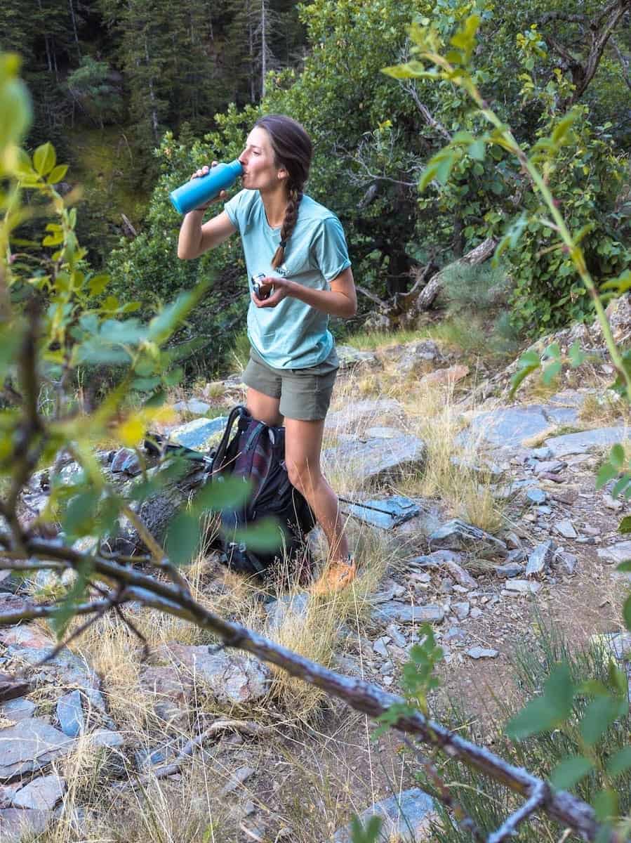 Hiker drinking water during La Porta del Cel route