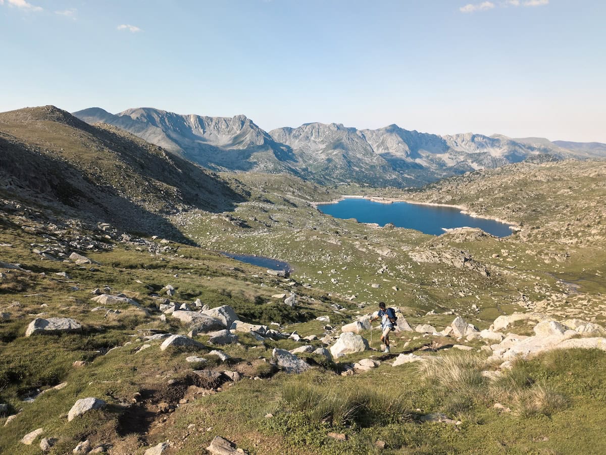 A hiker leaving behind Estany de l'Illa during the Coronallacs hike