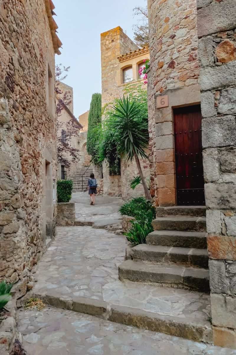 A woman walking around the medieval streets of Pals