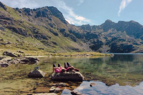 Two hikers taking a break at one of Andorra's lakes in summer