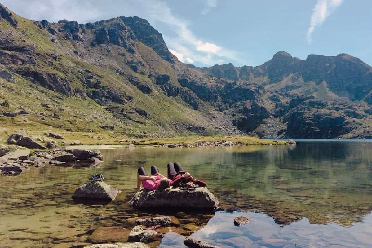 Two hikers taking a break at one of Andorra's lakes in summer