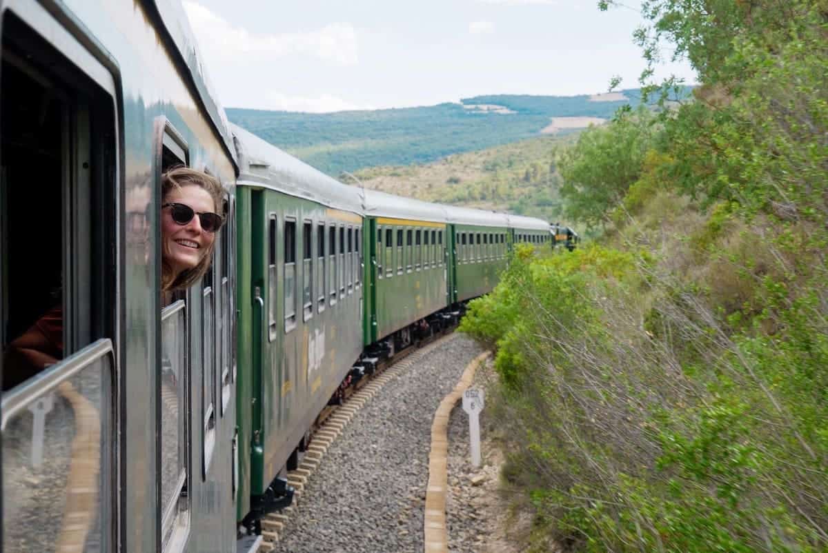 A person taking some air on the train's window